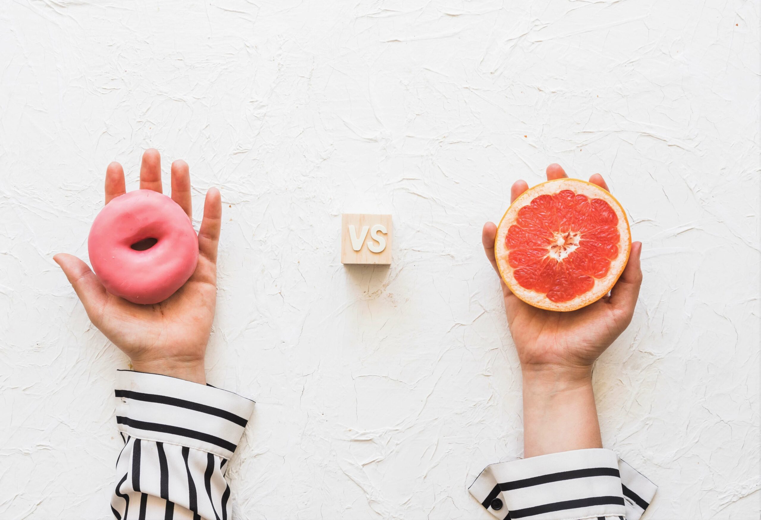 Une main tient un donut, l'autre un pamplemousse, vs entre les deux