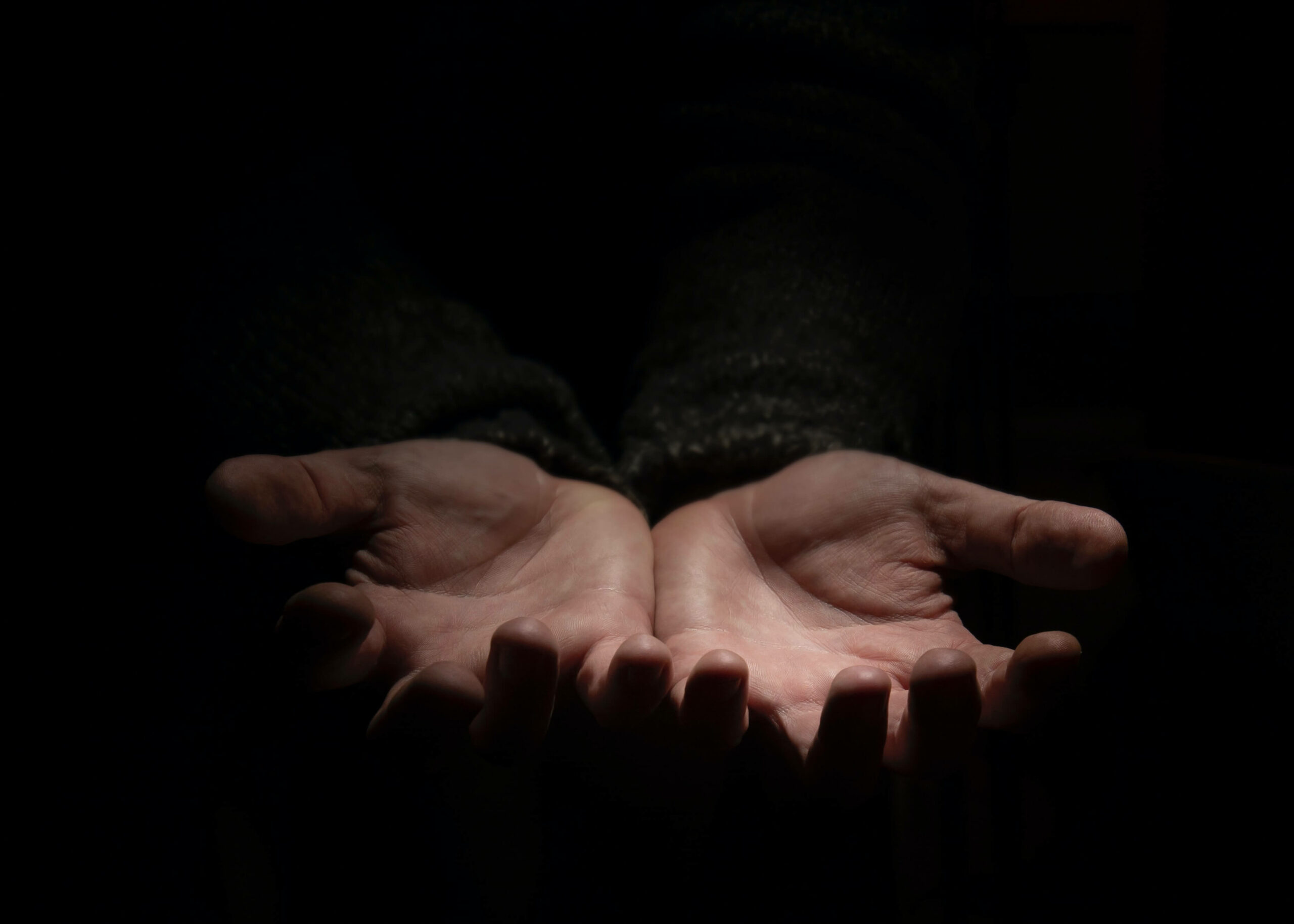 Une personne dans l'obscurité tant ses mains