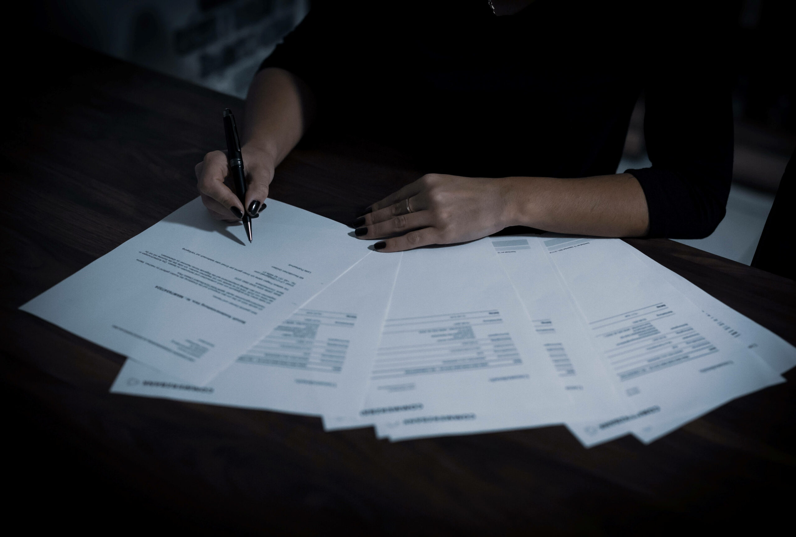 Une personne écrit sur plusieurs papiers